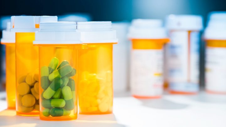 Pill bottles containing various prescription drugs on a table