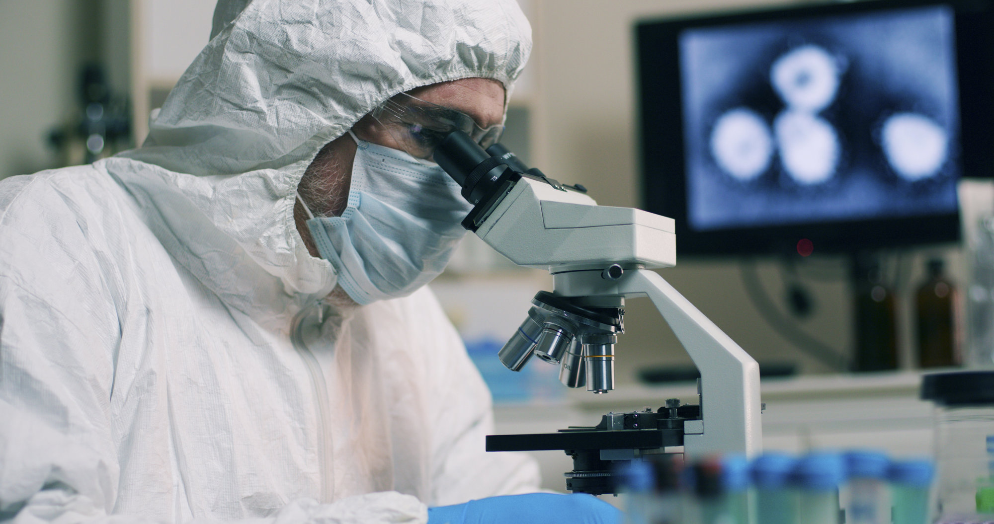 Doctor in a face mask with microscope