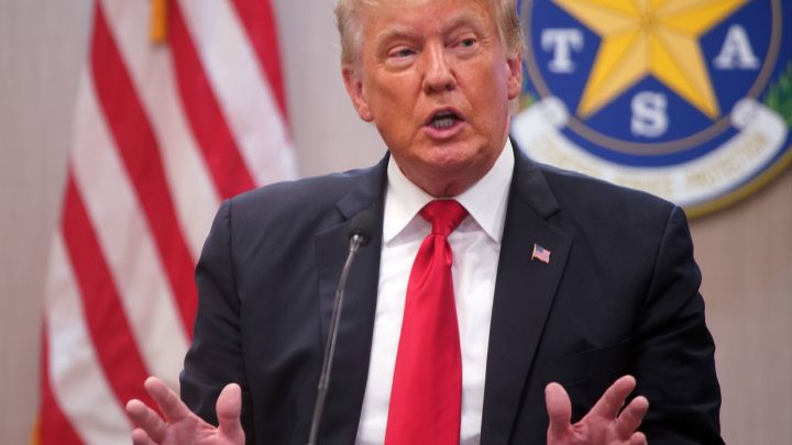 truth social president trump speaking in front of US flag