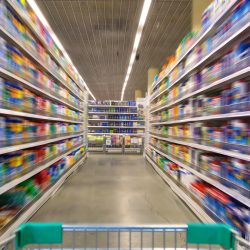 Shopping cart view fn a supermarket aisle and shelves